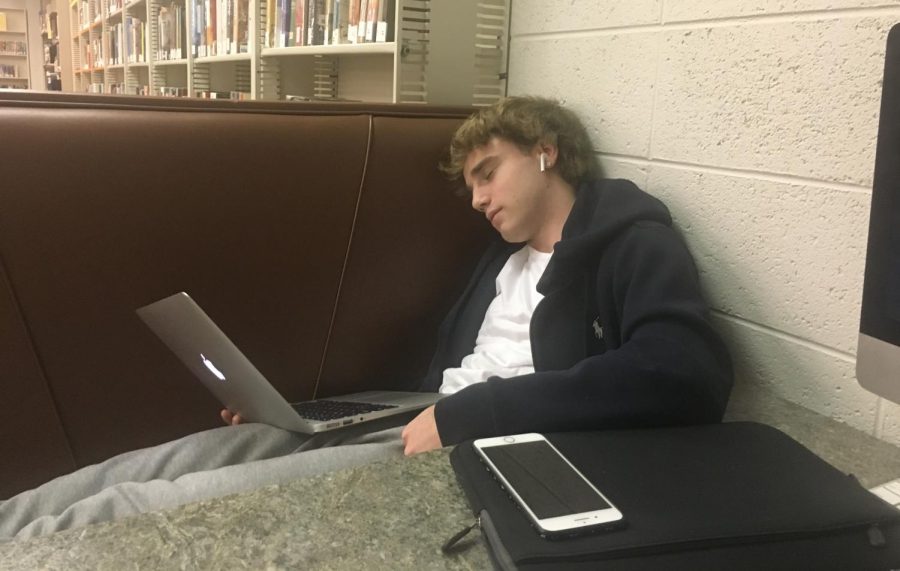 Friends Select Student sleeps in class while trying to finish work.