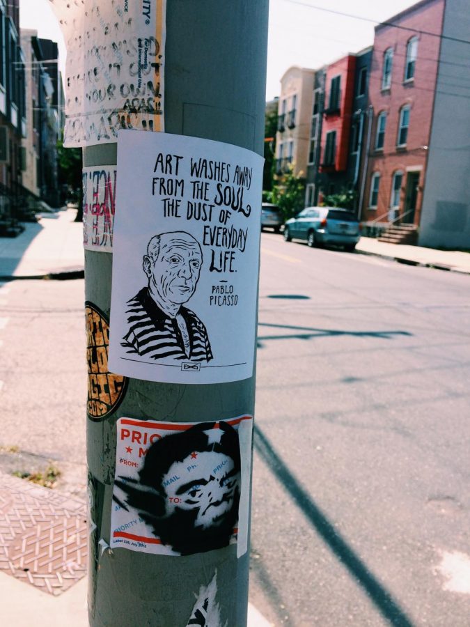 Picasso sticker placed on a street pole among other stickers. This was taken in Fishtown.