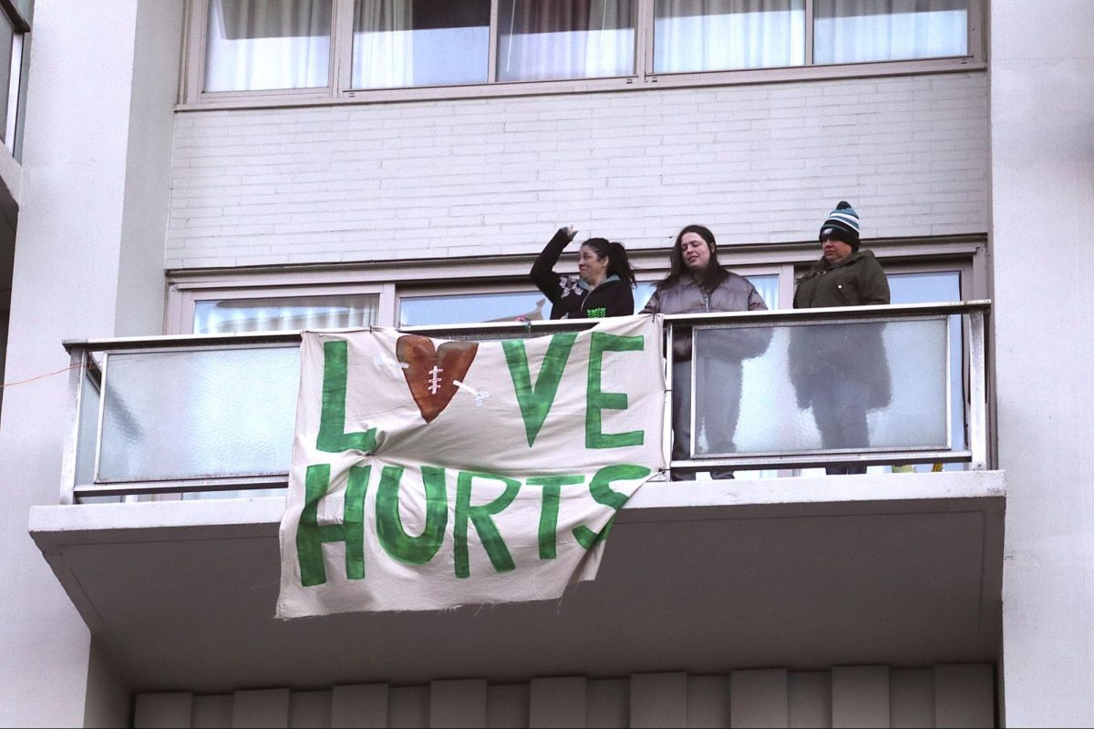 People hang a poster off of their balcony with the slogan “Love Hurts,” (A play on words showing support for Eagles quarterback Jalen Hurts.)