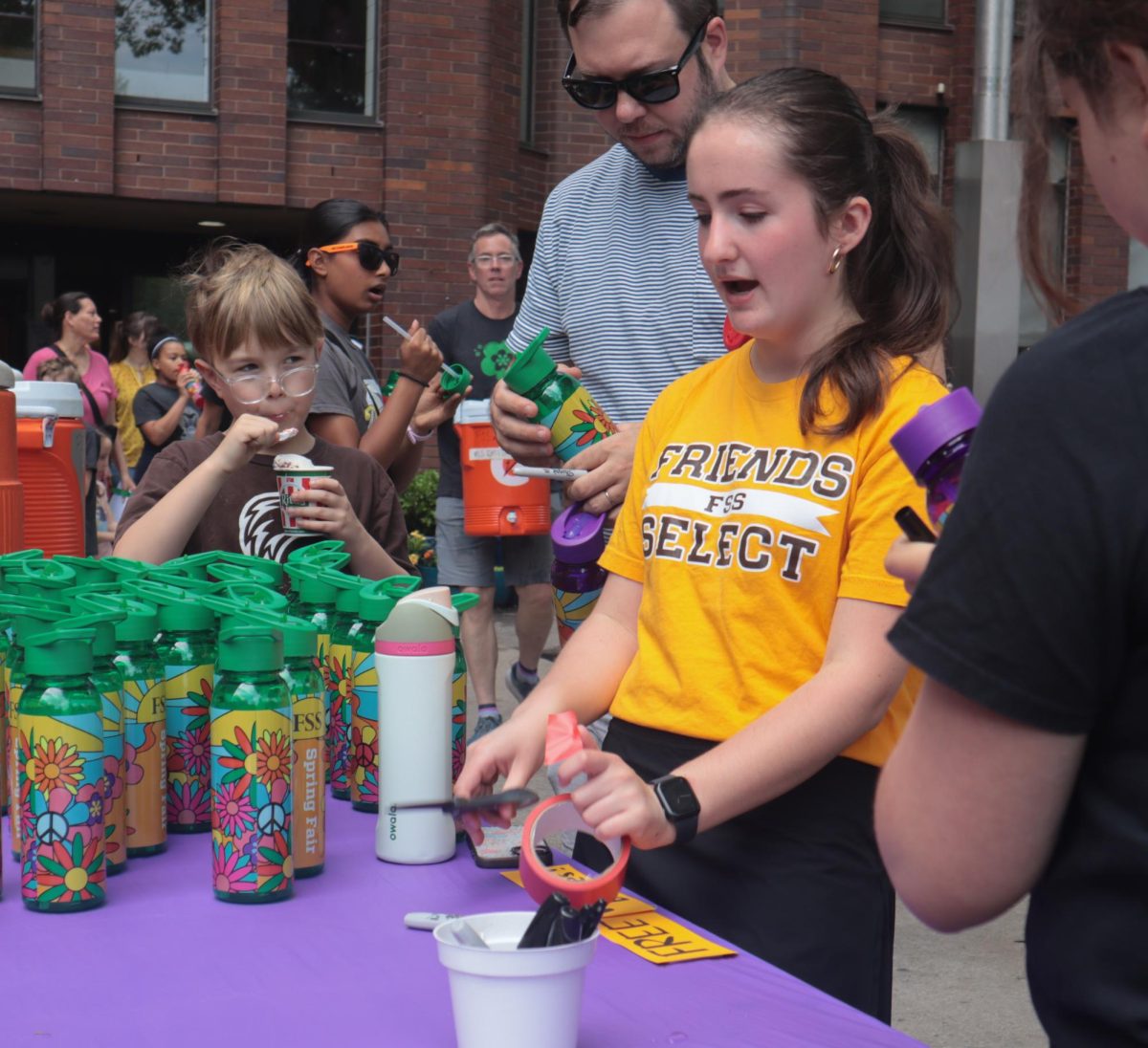 Talia Mono '26 labeling water bottles to be handed out.