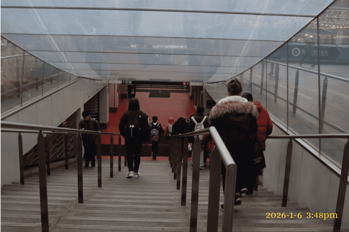 People walk down the stairs at City Hall SEPTA Station at 3:48 pm. This station serves as one of the main centers for transportation in the city.